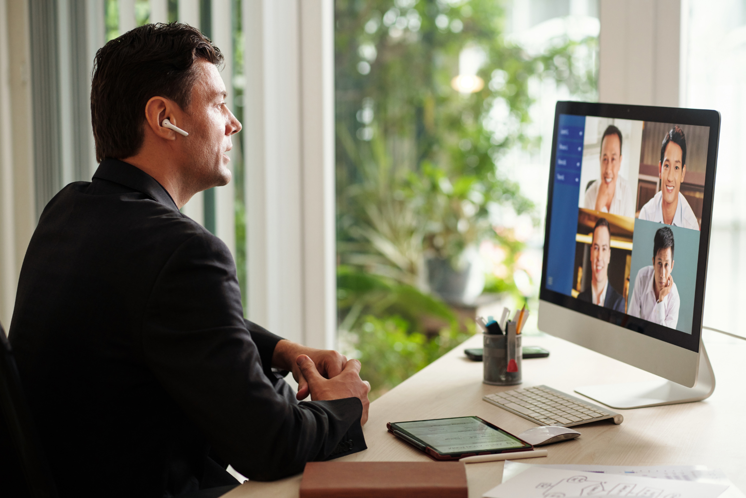Male employee in a virtual meeting on his computer in his home office.